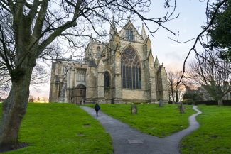 Ripon Cathedral's East End taken from the bottom of the hill in the Churchyard looking east. Image was taken in the winter and features grey skies & trees with no leaves.